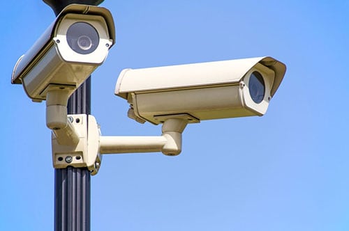 poled security cameras with blue sky background